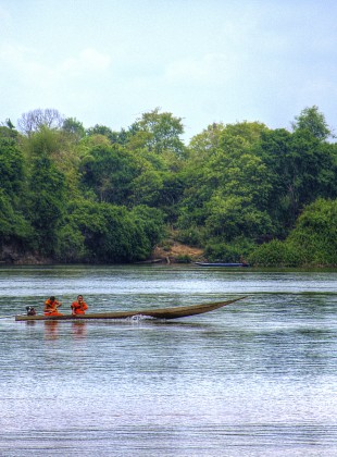 two buddhist monks driving a boat in Cambodia